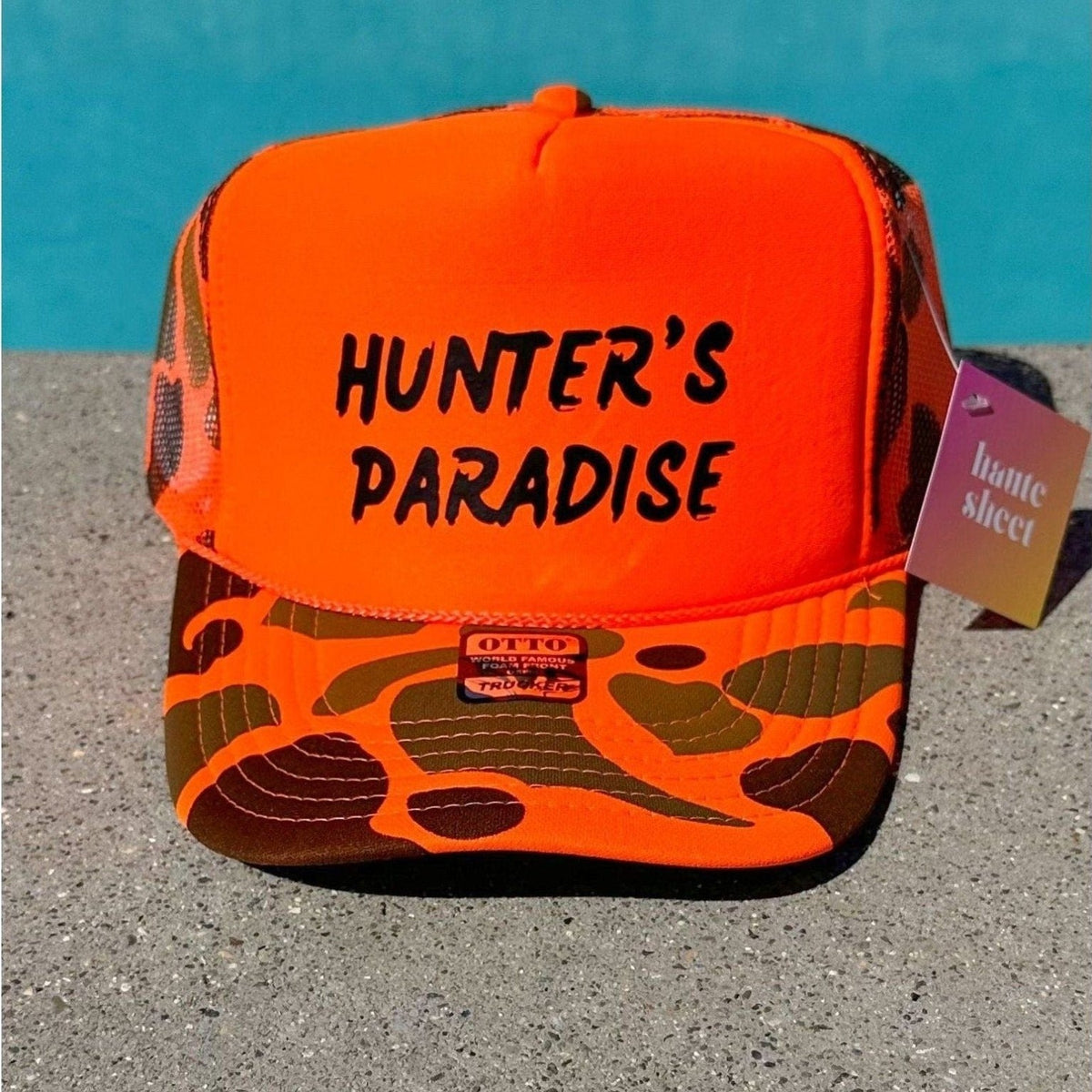 Orange Camo Trucker Hat that reads Hunters Paradise
